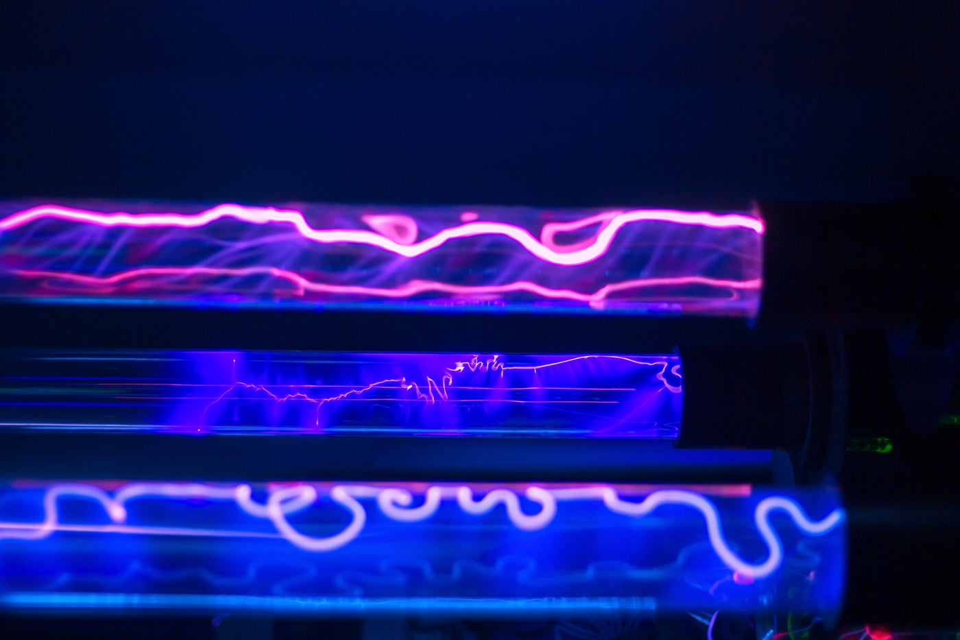 Close-up van UV-C lichtbuizen met paarse en blauwe gloed, gebruikt voor desinfectie tegen micro-organismen zoals huisstofmijt en bacteriën.